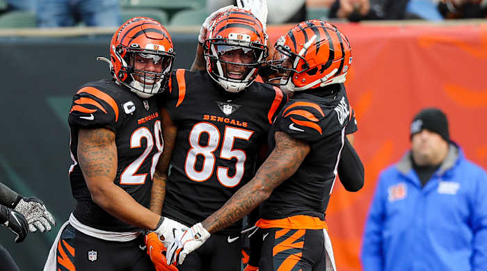 Tee Higgins smiles as Joe Mixon and Ja’Marr Chase hug him from either side